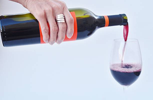 istock Pouring red wine into a wine glass. 502817441