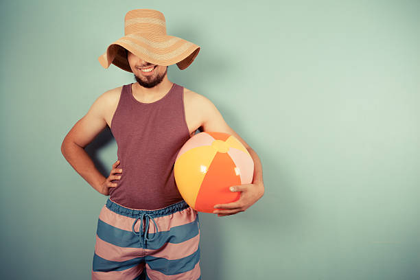istock Happy young man with beach ball and sun hat 502817979