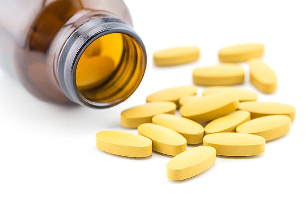 istock Pills of vitamin C spilled out open container 502818404