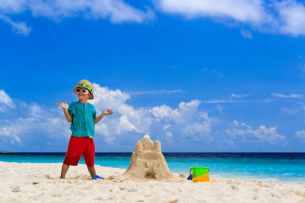 istock happy child with built sand castle on the beach 502818811