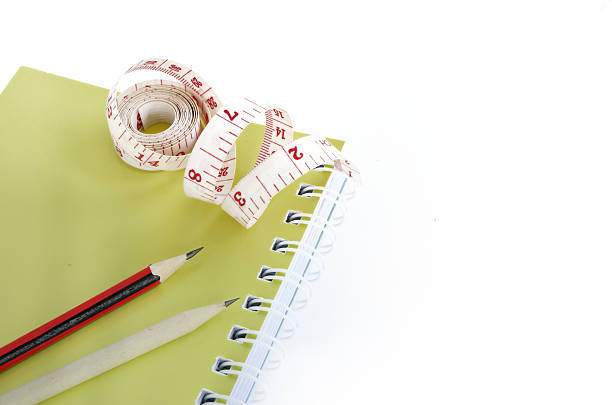 istock book and pencils with tape measuring on white 502818839