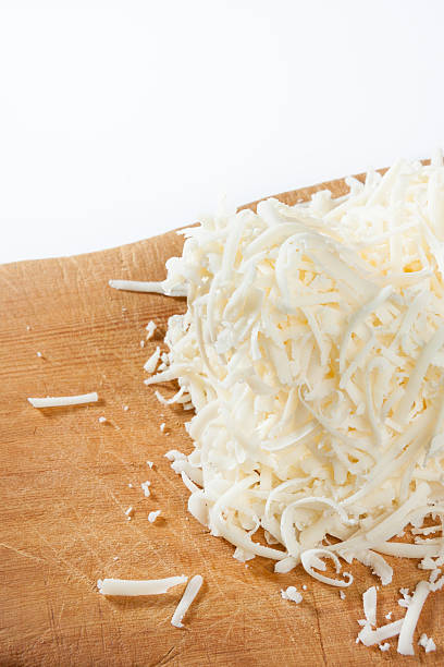 Shredded cheese Shredded mozzarella cheese on vintage wood cutting board shredded mozzarella stock pictures, royalty-free photos & images