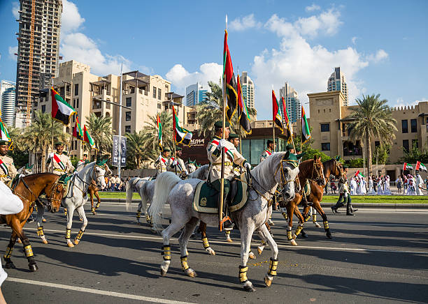 UAE National Day Dubai, United Arab Emirates, November 28, 2015: Mounted soldiers ride horses during celebrations for United Arab Emirates National Day in Dubai, United Arab Emirates arab man riding horse stock pictures, royalty-free photos & images