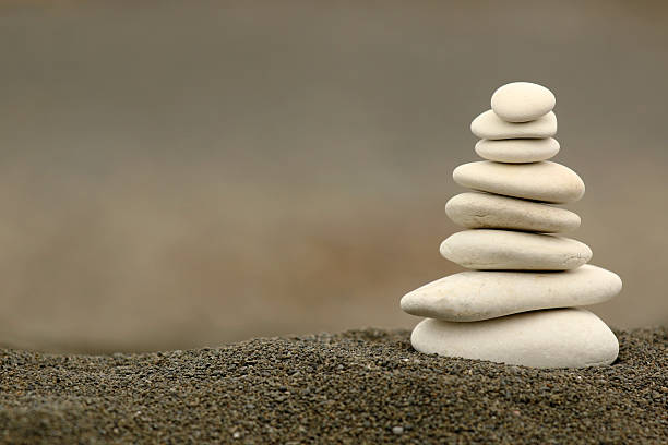 White balance zen stones Balancing silky white stones in black grain sand stack rock stock pictures, royalty-free photos & images