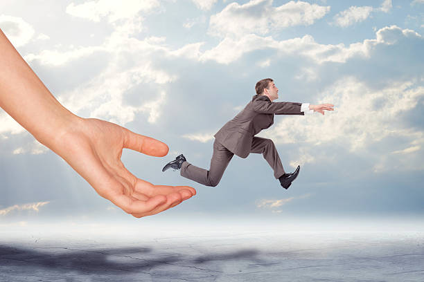 istock Hand catching businessman running forward 502841958