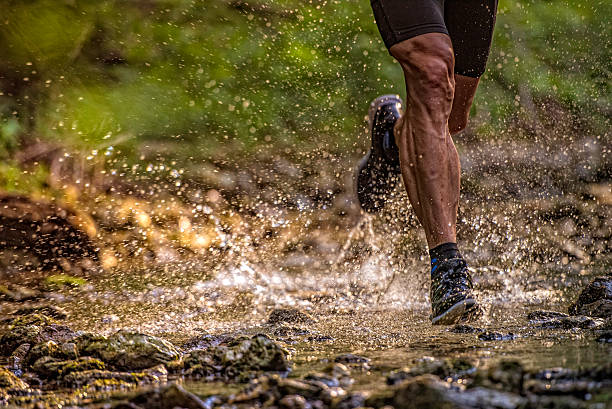 istock Man running across a stream, water splashing 502843900