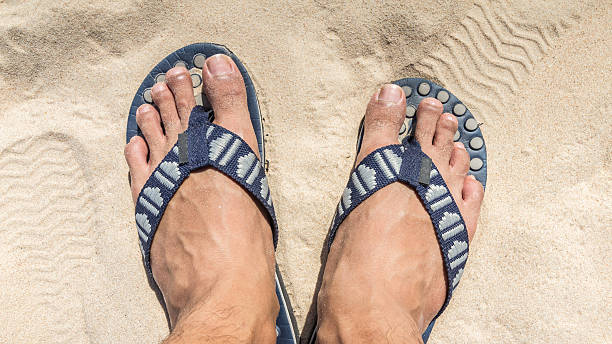 istock Man feet wearing flip flops on a beach 502846228