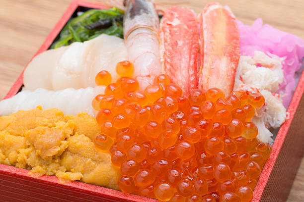 Bowl of rice topped with sashimi Carrying a variety of sashimi on top of vinegared rice is a Japanese lunch box. snow crab photos stock pictures, royalty-free photos & images