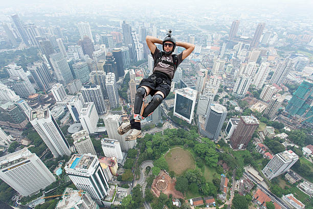 BASE jumpers in jumps off from Kuala Lumpur Tower, Malaysia. stock photo