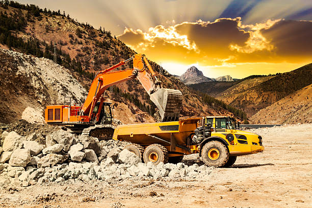istock Excavator loading dumper truck at sunset 502851476