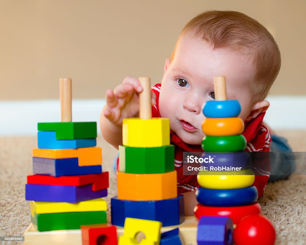 Niño jugando con juguetes de aprendizaje de apilado - Foto de stock de Bebé libre de derechos