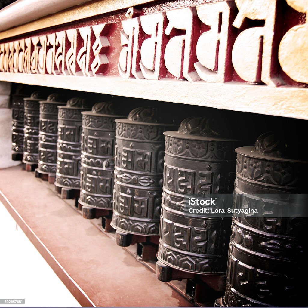 Tibetan Prayer Wheels vintage effect. Metal drums inscribed with mantras. Tibetan Prayer Wheels - vintage effect. Metal drums inscribed with mantras - retro filter. Buddhist Wheel Symbol. Patan Durbar Square. Kathmandu. Nepal. Alphabet Stock Photo