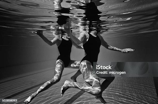 Synchronized Swimmers Underwater Stock Photo - Download Image Now - Artistic Swimming, Black And White, Swimming