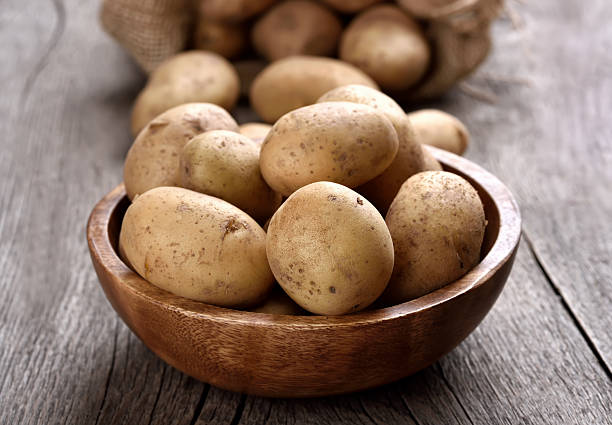 istock Raw potatoes in wooden bowl 502858824