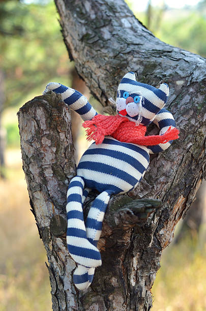 istock Handmade toy cat relaxing on a tree 502860391