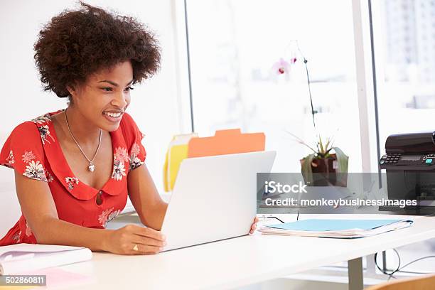 Smiling Woman Looking At Silver Laptop In Studio Stock Photo - Download Image Now - 20-29 Years, Adult, Adults Only