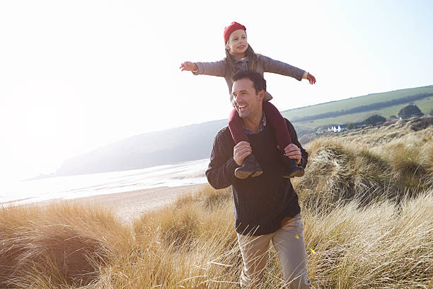istock Father And Daughter Walking Through Dunes On Winter Beach 502861169