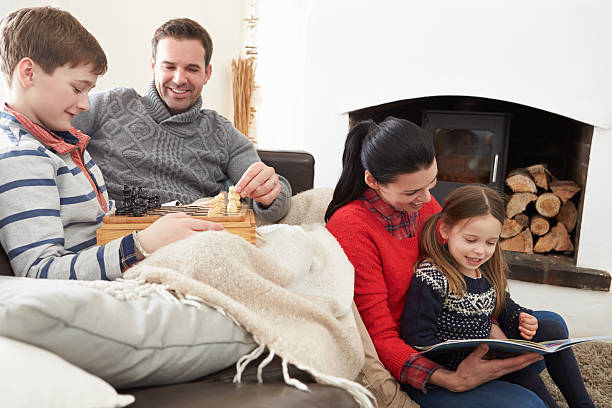 istock Family Relaxing Indoors Playing Chess And Reading Book 502861237