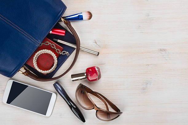 View on women bag stuff with copyspace on wooden background View on women bag stuff with copyspace on wooden background belongings stock pictures, royalty-free photos & images