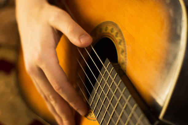 istock Young guy playing on guitar. Hand and guitar close-up.Soft and blur conception 502866830