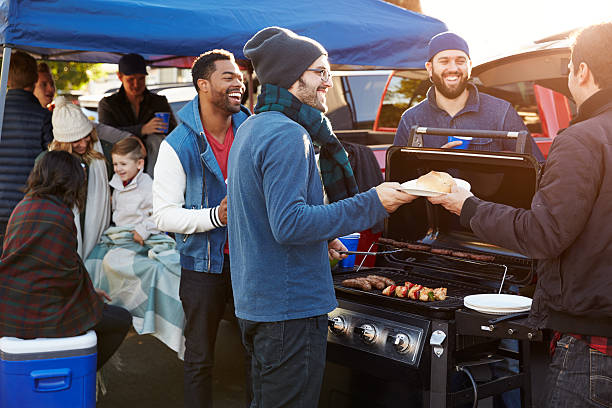 Group Of Sports Fans Tailgating In Stadium Car Park Group Of Sports Fans Tailgating In Stadium Car Park barbecue social gathering photos stock pictures, royalty-free photos & images