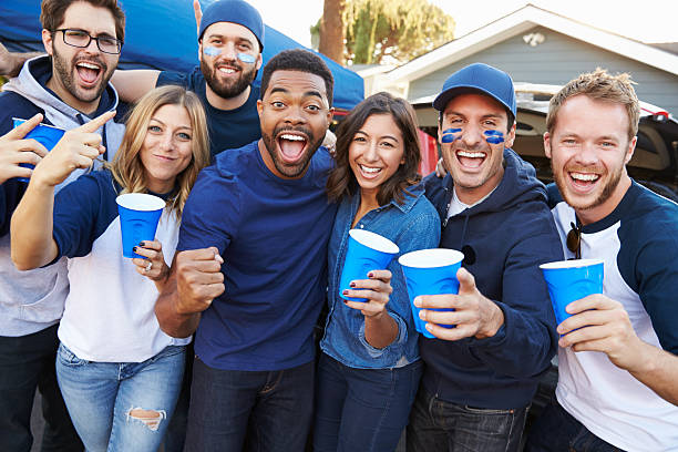 Group Of Sports Fans Tailgating In Stadium Car Park Group Of Sports Fans Tailgating In Stadium Car Park american football stadium stadium sport outdoors stock pictures, royalty-free photos & images
