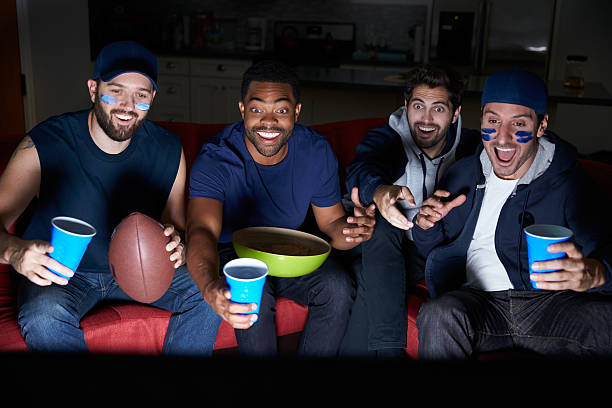 group of male sportfans vor dem spiel im fernsehen - sitting 20s adult american football stock-fotos und bilder