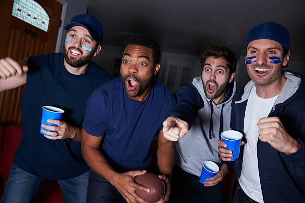 group of male sportfans vor dem spiel im fernsehen - sitting 20s adult american football stock-fotos und bilder