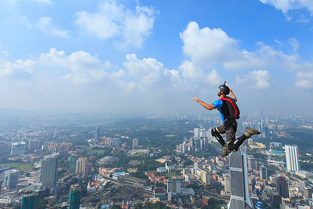 BASE jumpers in jumps off from Kuala Lumpur Tower, Malaysia. stock photo
