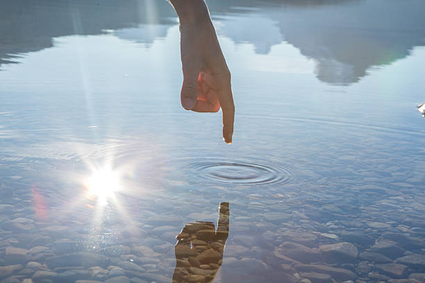 istock Finger touches surface of mountain lake 502885872