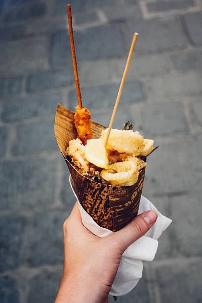 fried seafood, street food in cone held in hand.