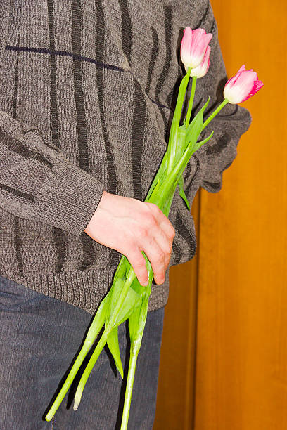 istock Three tulips in a male hand 502890722