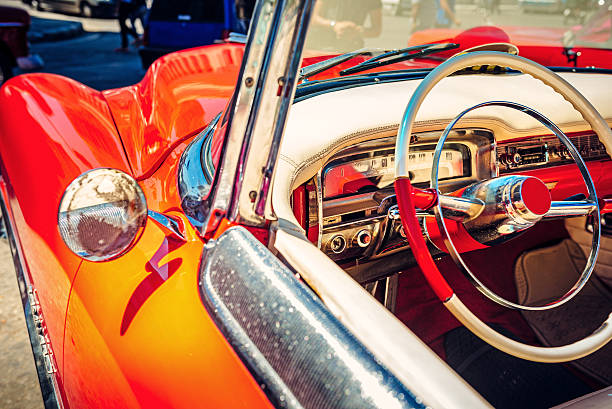The steering wheel and interior of a classic car.