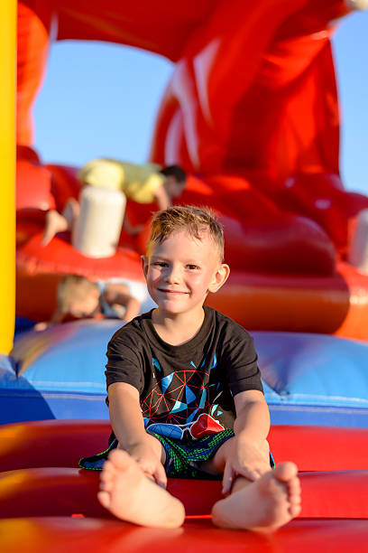 istock Smiling little boy sitting on a jumping castle 502891772