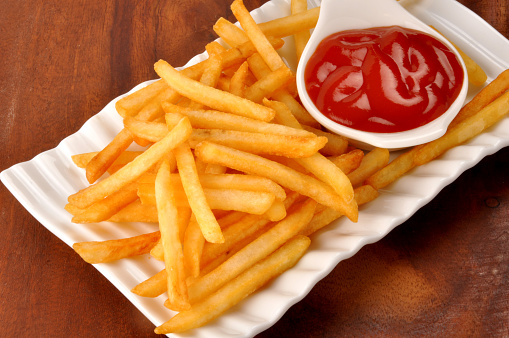 A delicious, spicy French Fries served with \tTomato Ketchup in beautiful dish