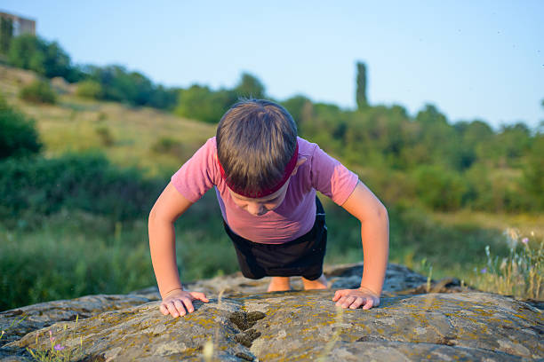 istock Sporty Young Boy Doing Push up on Top of Boulder 502894758
