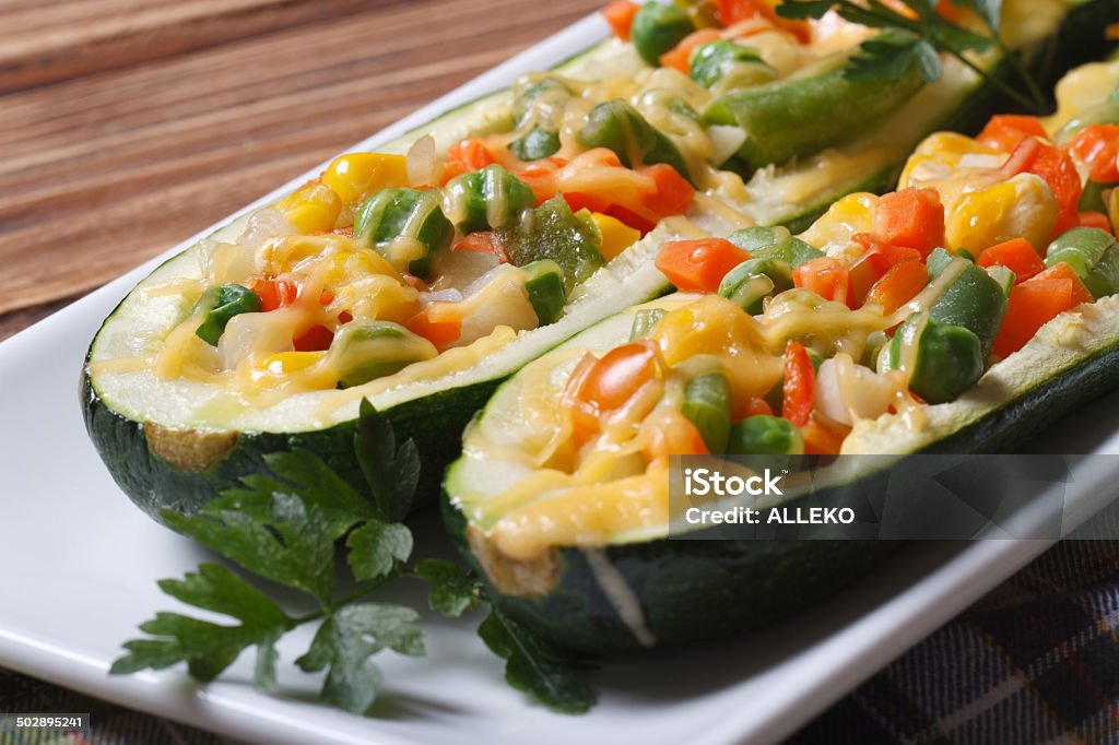 baked zucchini stuffed with vegetables closeup baked zucchini stuffed with vegetables closeup on wooden background. horizontal Appetizer Stock Photo