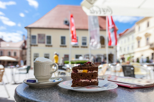 Enjoying a cup of coffee and a delicious cake in the pedestrian area in the city center of Moedling - Lower Austria