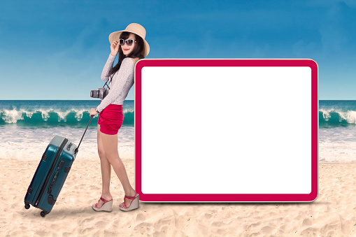 Young attractive woman standing next to copyspace. shot on the beach