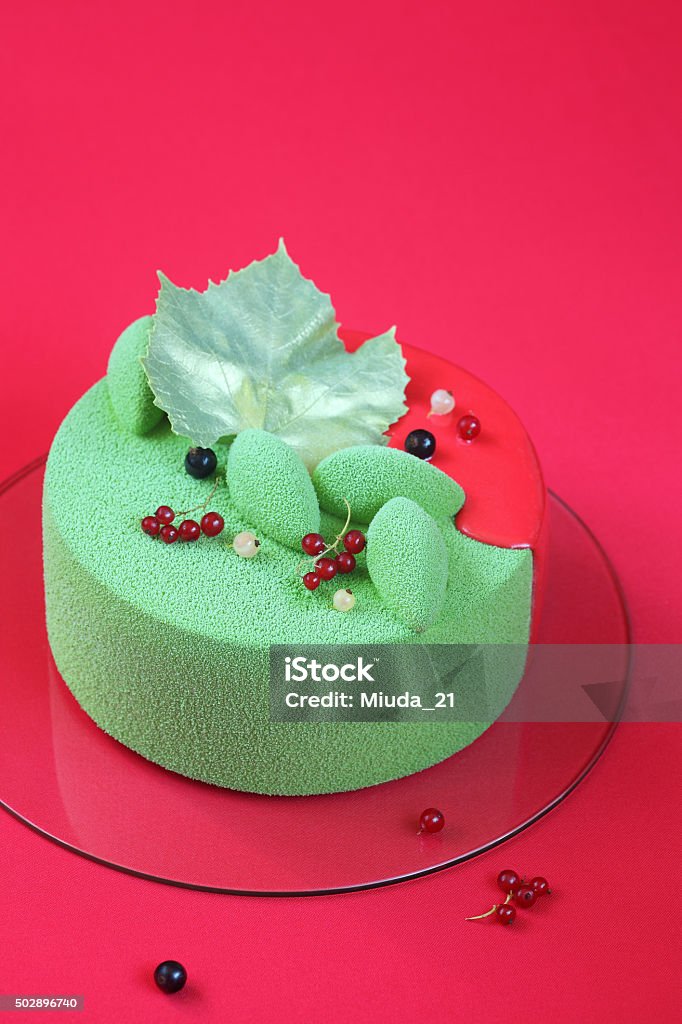 Celebration (Christmas) Matcha and Currants Mousse Cake Celebration (Christmas) Matcha and Currants Mousse Cake on a bright red background. 2015 Stock Photo