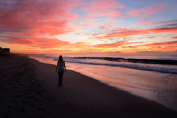 istock Woman relaxing on the beach at sunrise. 502898006