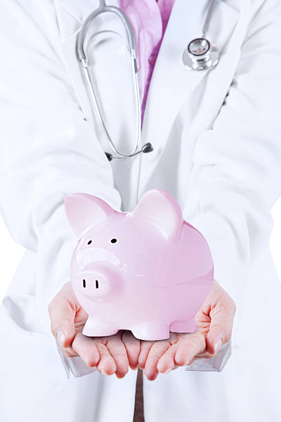 istock Doctor with Stethoscope Holding Piggy Bank 502905955