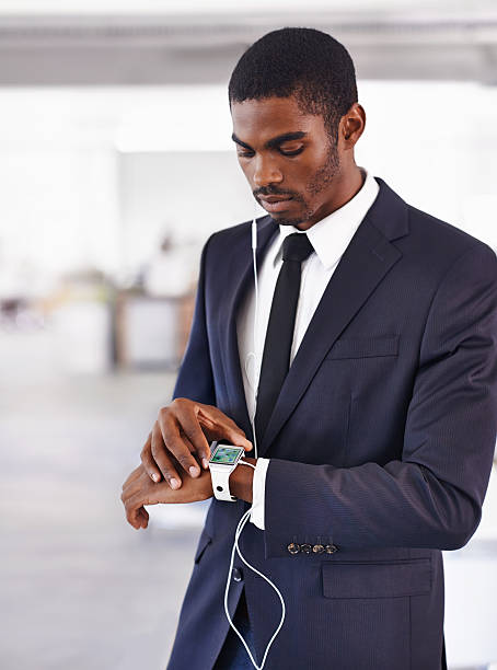 Connected to the digital world Cropped view of a young businessman wearing a smartwatch with a digital interface - All screen content is designed by us and not copyrighted by othershttp://195.154.178.81/DATA/i_collage/pi/shoots/783764.jpg smart watch business stock pictures, royalty-free photos & images