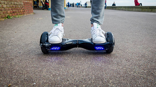 pessoa em uma hoverboard em um público de trilha de pedestres - segway - fotografias e filmes do acervo