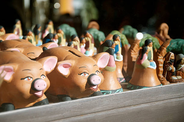 Pumamarca, Argentina - April 15, 2014: Terracota Souvenirs in Pumamarca Argentina. Terracota souvenirs are on display on a window in the shape of a pig bank, and native people.