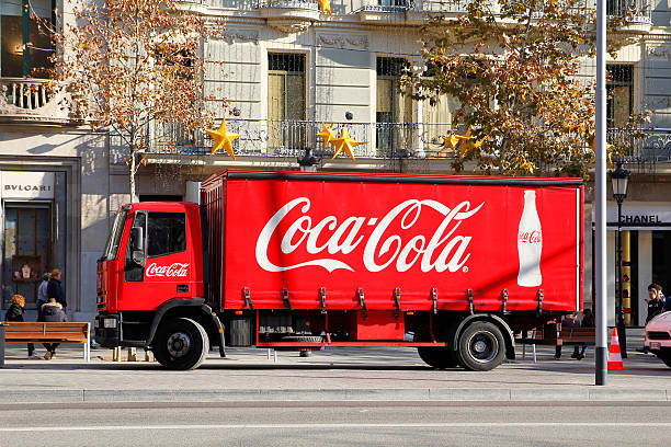 Barcelona, Spain - December 28, 2015:  Red Coca-Cola delivery truck parked in the street, in the Passeig de Gracia at Barcelona, a famous landmark in the city on Christmas