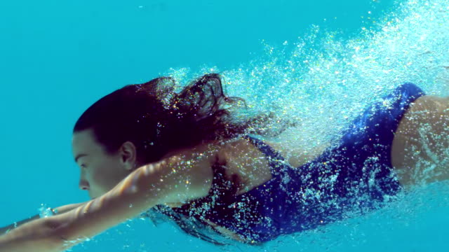 Brunette woman swimming underwater