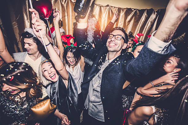 New Year's Eve Celebration Smiling group of people celebrating New Year's Eve with confetti, sparklers and balloons, and toasting with champagne rudolph the red nosed reindeer photos stock pictures, royalty-free photos & images