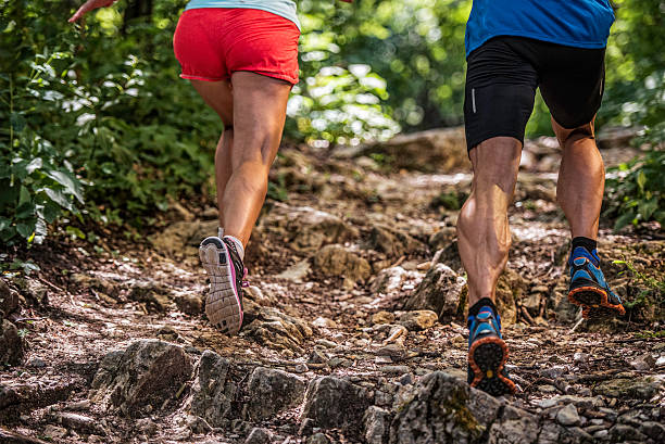 istock Woman and man running up a rocky forest path 502919296
