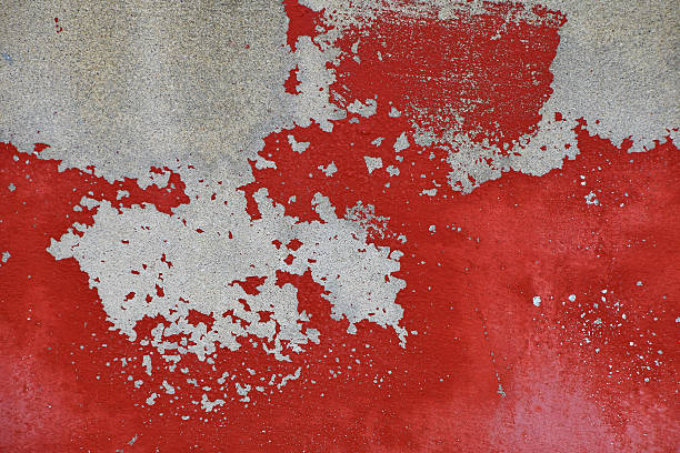 istock Flakes of old red paint on grey concrete wall 502919510